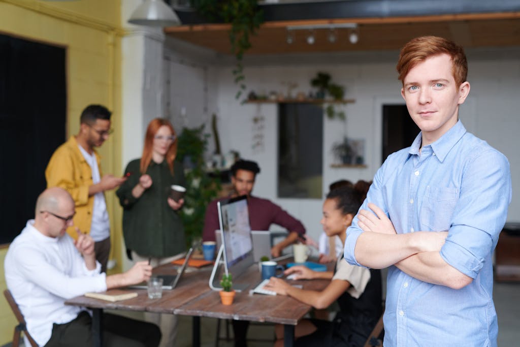 Young professional leading a diverse team in a contemporary office setting.